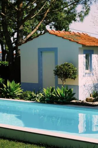 a house with a swimming pool in front of a house at Casa Oliva - Casa do Lago in Porto de Mós