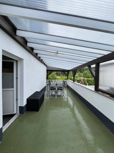a patio with a table and chairs on a roof at Modern und Rustikal mit Kamin Ferienwohnung Kohlert in Bad Berleburg