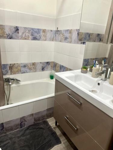 une salle de bain avec une baignoire et un lavabo et une baignoire dans l'établissement Beautiful 2 beds rooms and living room 3 minutes beaches, à Beaulieu-sur-Mer