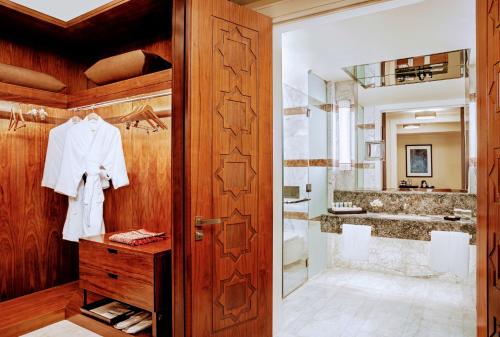 La salle de bains est pourvue d'une porte en bois et d'un lavabo. dans l'établissement Conrad Makkah, à La Mecque