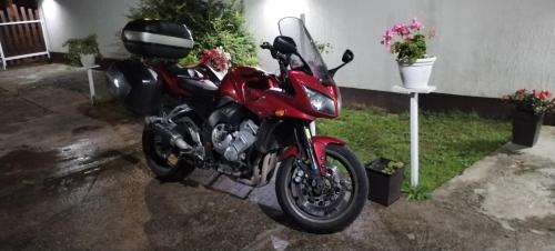 a red motorcycle parked in a parking lot at Sobe Lara in Donji Milanovac