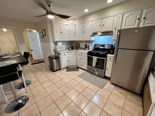 a kitchen with white cabinets and a stainless steel refrigerator at 7-A Diamond in Yonkers in Yonkers