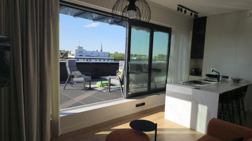un soggiorno con vista su un balcone di Artisa Riia Str 22 Luxury Penthouse Apartment - 8th fl a Tartu