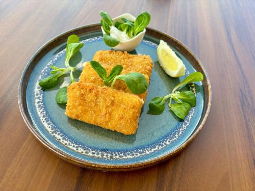 a blue plate with some food on a table at Rooms & Pansion Odmor in Rovanjska