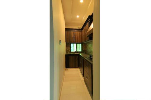 a kitchen with wooden cabinets and a hallway at Candle Wood in Bhurban