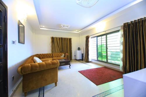 a living room with a couch and a window at Candle Wood in Bhurban