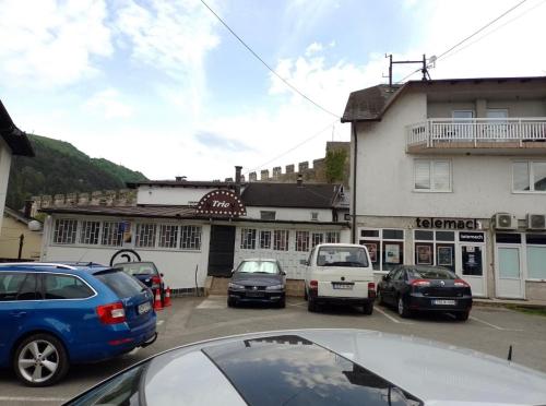 a parking lot with cars parked in front of a building at TRIO sobe in Jajce