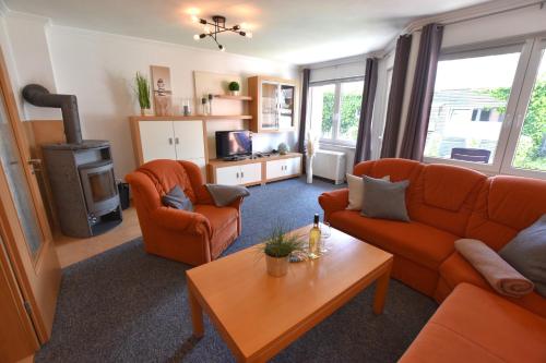un soggiorno con 2 divani arancioni e un tavolo di 2020 Bungalow "Strandhüdde" a Dahme