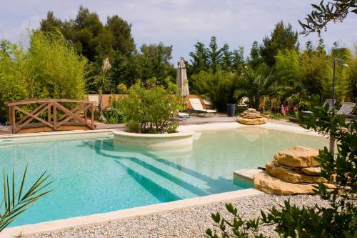 une piscine avec de l'eau bleue dans une cour dans l'établissement Le Mûrier, à Laouque