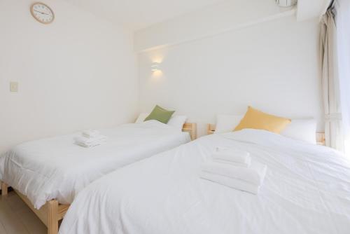 two beds sitting next to each other in a bedroom at 錦系町天空樹景觀飯店 Skytree View Kinshicho in Tokyo