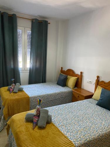 チクラナ・デ・ラ・フロンテーラにあるApartamento Taymarのベッドルーム1室(青と黄色のシーツが備わるベッド2台付)