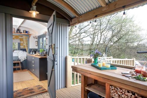 cocina abierta y zona de comedor con mesa de madera en Hawkings Hideaway, en Knowstone