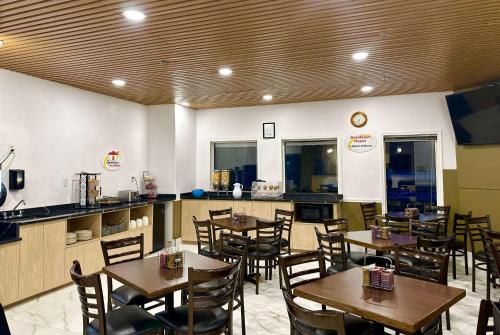 un restaurante con mesas y sillas de madera y una barra en Super 8 by Wyndham Hinton, en Hinton