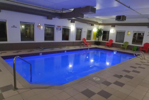 a large pool with blue water in a building at Super 8 by Wyndham Hinton in Hinton
