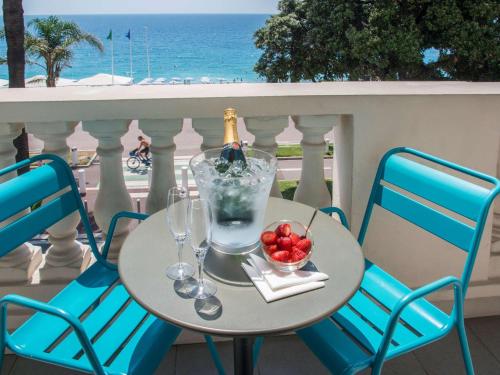 - une table avec une bouteille de vin et un bol de fruits dans l'établissement Mercure Nice Marché Aux Fleurs, à Nice