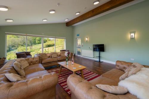a large living room with couches and a table at Godshill Park Barn in Ventnor