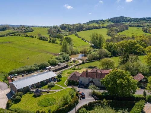 an aerial view of a farm with a building and trees at Godshill Park Barn in Ventnor