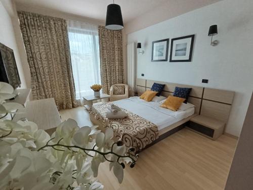 a bedroom with a bed and a couch and a table at Vila Sangria in Mamaia Nord