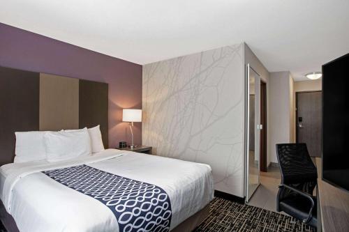 um quarto de hotel com uma cama e uma cadeira em La Quinta by Wyndham Fayetteville em Fayetteville