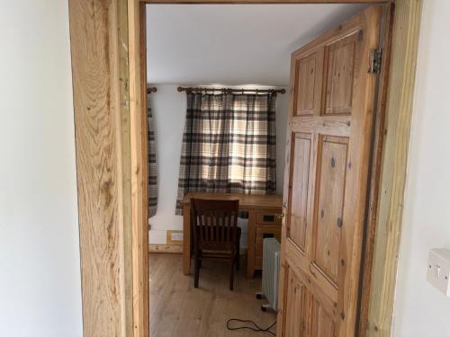Cette chambre comprend un bureau, une chaise et une porte. dans l'établissement Nikolay’s House, à Bristol