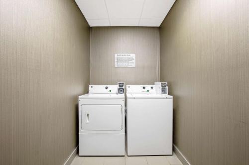 pralnia z białą pralką i suszarką w obiekcie La Quinta by Wyndham Fayetteville w mieście Fayetteville