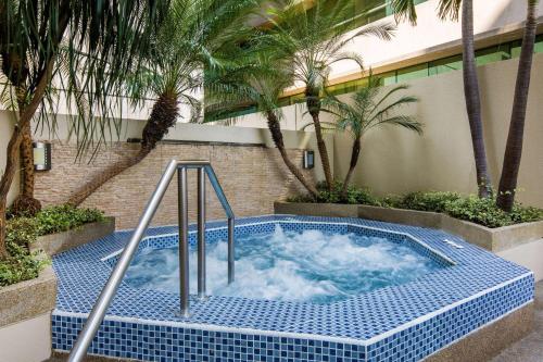 a hot tub in a courtyard with palm trees at Wyndham Garden Guayaquil in Guayaquil