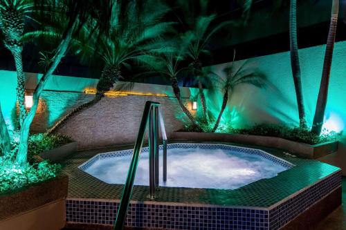 a swimming pool at night with palm trees and lights at Wyndham Garden Guayaquil in Guayaquil