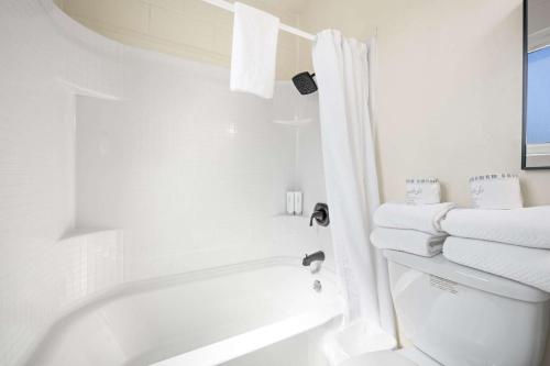 ein weißes Bad mit einer Badewanne, einem WC und Handtüchern in der Unterkunft Econo Lodge Inn & Suites Heavenly Village Area in South Lake Tahoe