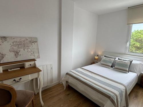 Schlafzimmer mit einem Bett, einem Schreibtisch und einem Fenster in der Unterkunft Rosa dels Vents Port d'Aro in Platja  d'Aro