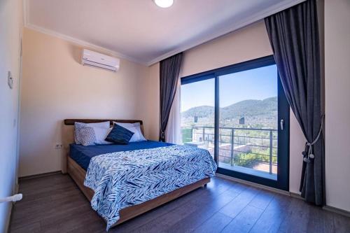 a bedroom with a bed and a large window at Bodrum Kızılağaçta özel havuzlu geniş bahçeli lüks Villa in Bodrum City