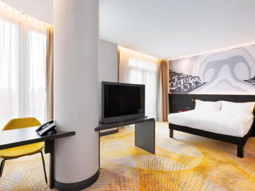 ibis Styles Istanbul Merter في إسطنبول: غرفة فندقية بسرير وتلفزيون بشاشة مسطحة