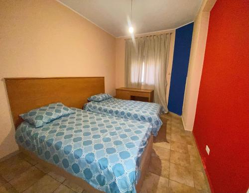 a bedroom with a bed with a blue comforter at Olympia in Kfardebian