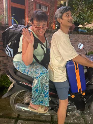 una mujer sentada en una moto junto a un hombre en Viet Anh Homestay, en Ninh Binh