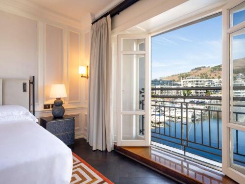 a bedroom with a bed and a large window at Cape Grace, A Fairmont Managed Hotel in Cape Town