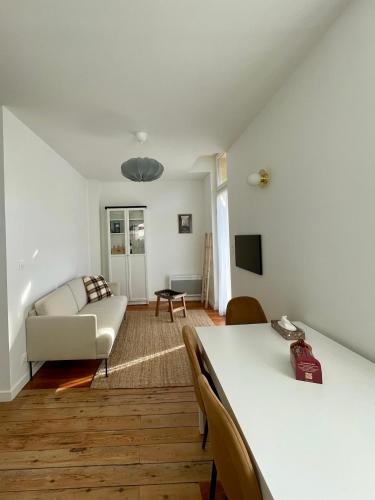ein Wohnzimmer mit einem Sofa und einem Tisch in der Unterkunft Montfaucon - Élégant appartement & terrasse au cœur de Bordeaux, idéalement situé in Bordeaux