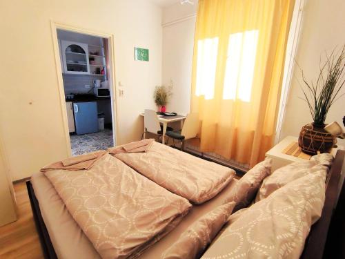 a bedroom with a bed and a table and a window at Caesar Residence in Budapest