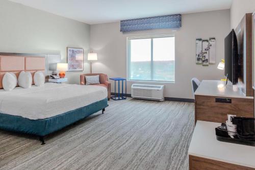 ein Hotelzimmer mit einem Bett und einem TV in der Unterkunft Hampton Inn & Suites Indianapolis West Speedway in Indianapolis