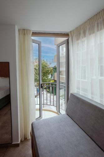 a bedroom with a bed and a large window at Griffin Suites in Heraklio Town
