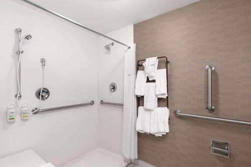 uma casa de banho com chuveiro, WC e toalhas em Hawthorn Extended Stay by Wyndham Knoxville em Knoxville