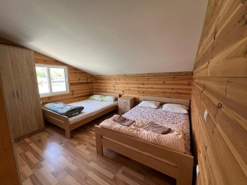 Habitación con 2 camas en una cabaña de madera en Pearl Cottage Ada Bojana en Ulcinj