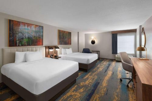 Habitación de hotel con 2 camas y escritorio en Hawthorn Extended Stay by Wyndham Knoxville en Knoxville