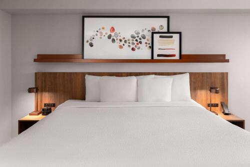 a bed in a hotel room with a white bed at Hawthorn Extended Stay by Wyndham Knoxville in Knoxville