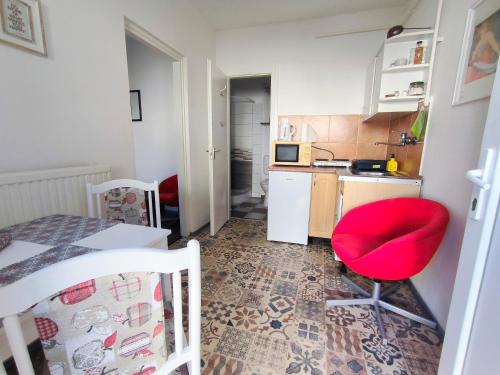 una pequeña cocina con una silla roja y una mesa en Caesar Residence en Budapest