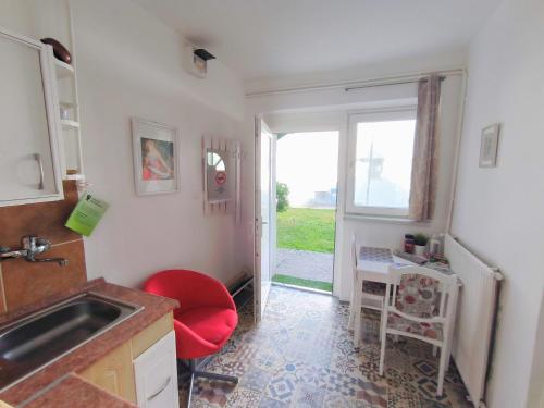 a kitchen with a sink and a red chair at Caesar Residence in Budapest