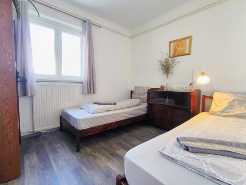 a small room with two beds and a window at Caesar Residence in Budapest
