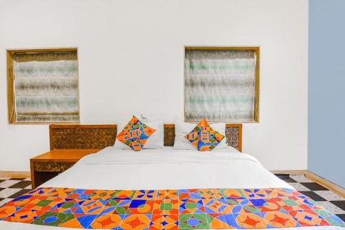 ニューデリーにあるHotel Moody Moon budget friendly stay near igi international airport delhiのベッドルーム1室(カラフルなキルトのベッド1台付)