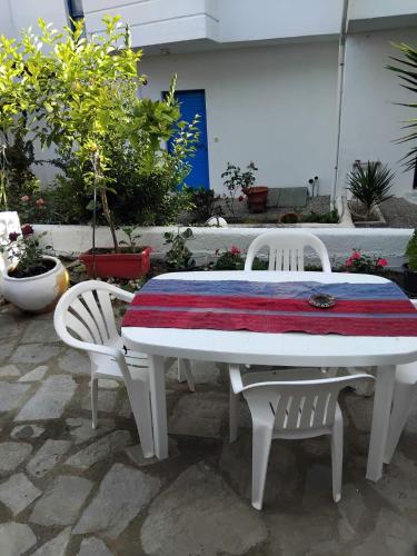 a white table with two chairs and a red and white blanket on it at Kriopigi Garden in Kriopigi