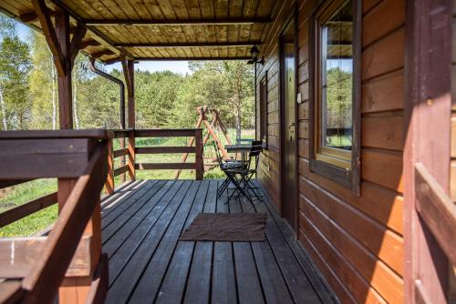 a porch of a cabin with a bench on it at Agroturystyka Letnisko - Michał in Stara Kiszewa