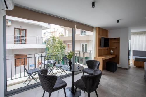 a room with a balcony with a table and chairs at Griffin Suites in Heraklio