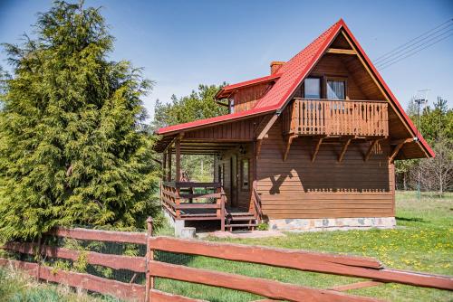 a wooden cabin with a fence in front of it at Agroturystyka Letnisko - Michał in Stara Kiszewa